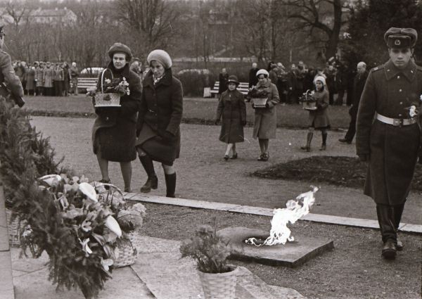 Foto: Enno Kapstas, asutuste esindajad lillekorve toomas, Suure Sotsialistliku Oktoobrirevolutsiooni 60. aastapäeva miiting vennaskalmistul, 3.11.1977, RM Fn 1543:3411, Virumaa Muuseumid SA, http://www.muis.ee/museaalview/2349781.   